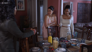 Priya and Avani Nandra-Hart stand next to the table as they talk to Suki Panesar.