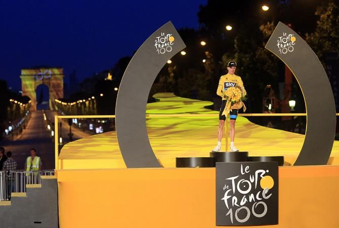 Chris Froome dwarfed by the enormity of the yellow jersey podium