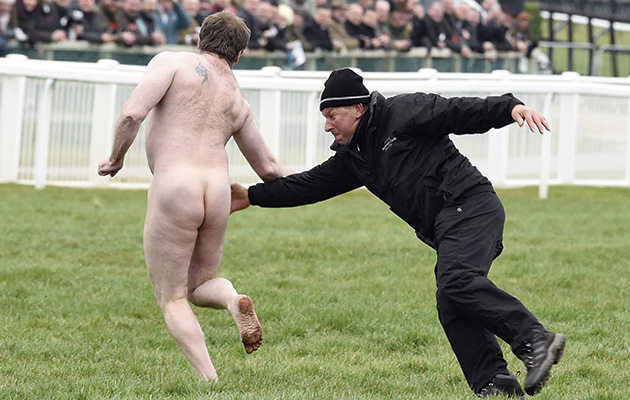 A streaker wriggles out of a tackle before the Cheltenham Foxhunter Chase
