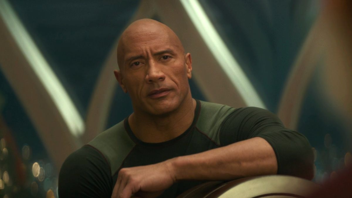 Dwayne Johnson looks ahead in conversation with a stoic expression in Red One. 