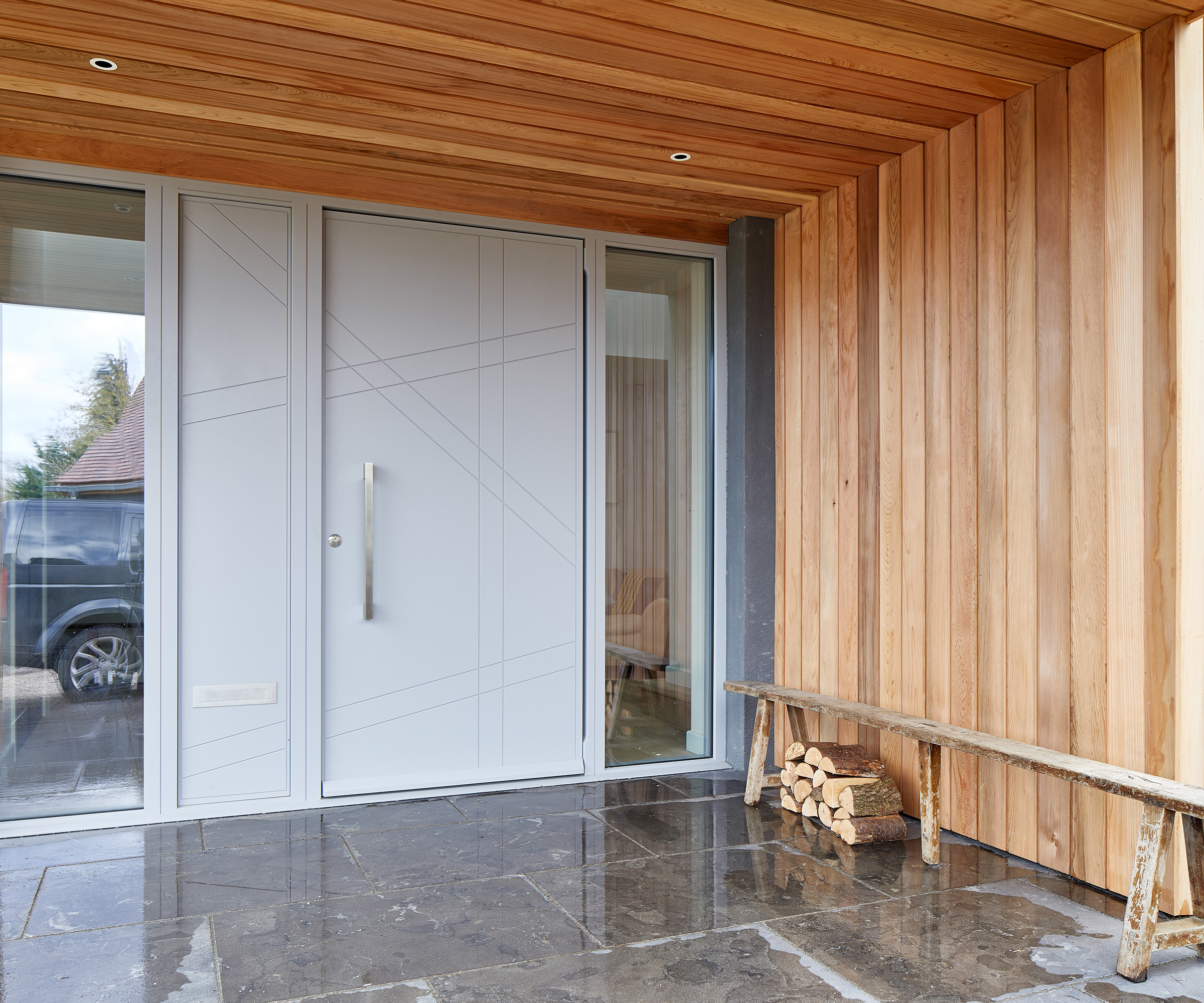 modern grey front door in modern timber clad porch