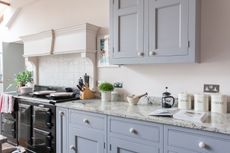 interior of kitchen in grade i listed tudor home with grey cabinets and aga