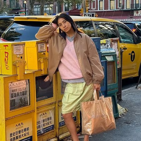 @himichelleli wearing barn jacket, pink sweater, lime green skirt, and tote bag