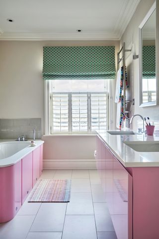 Pink bathroom with a green roman blind