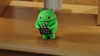 the android show mascot with a filmmslate on a wooden bench
