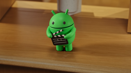 the android show mascot with a filmmslate on a wooden bench