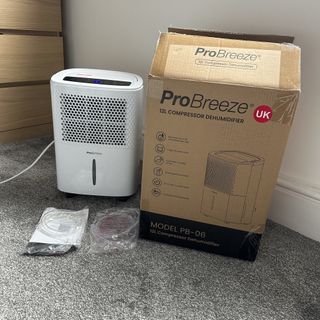 The Pro Breeze 12L Low Energy Dehumidifier being unboxed in a carpeted room