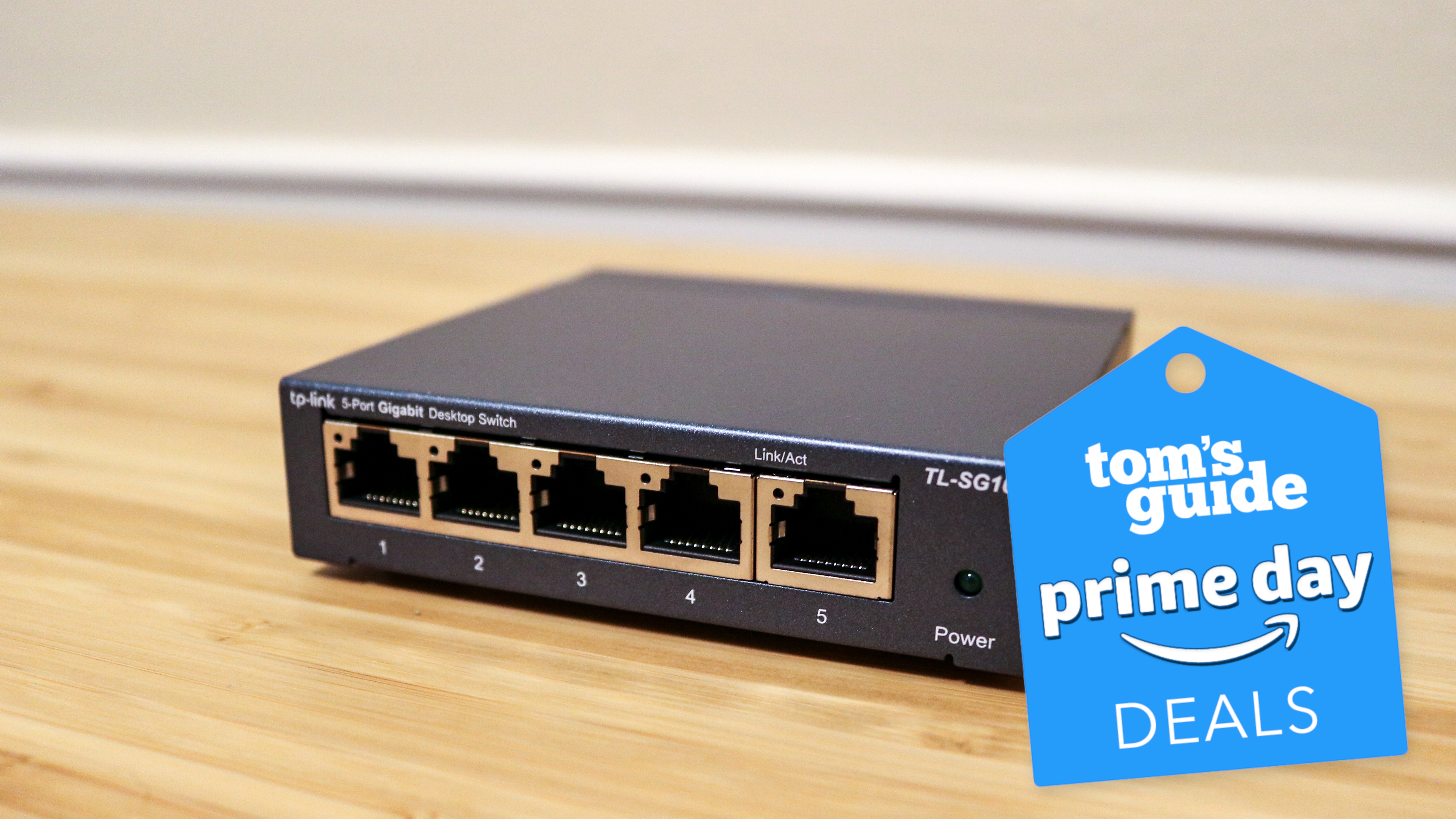 A four port, unmanaged network switch from TP-Link on a desk with a Tom's Guide deals badge on top