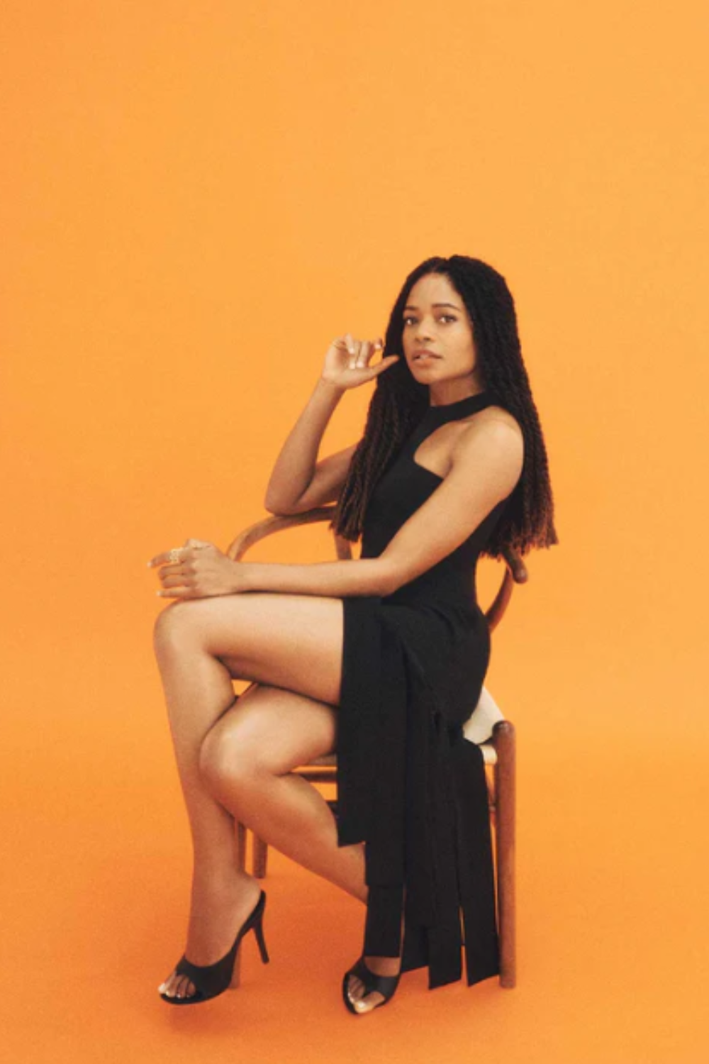 naomie wearing a black midi dress with panelled hem detail