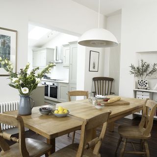 living room with white walls wooden flooring and dinning table with chairs