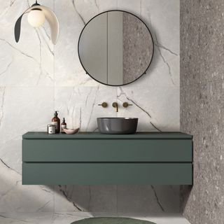 bathroom trends, modern style bathroom with green wall hung vanity, marble style tiles on floor and walls, round mirror, pendant light