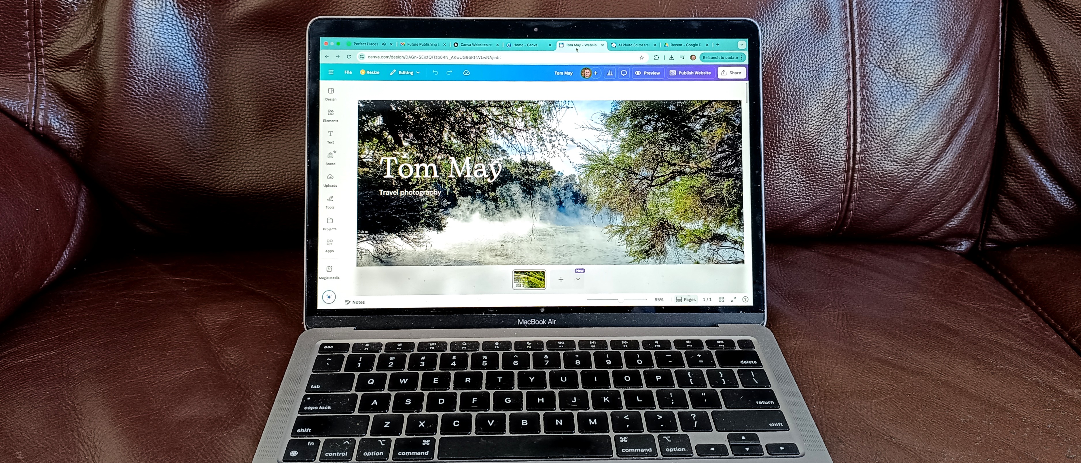 Canva website being edited on laptop sitting on leather sofa