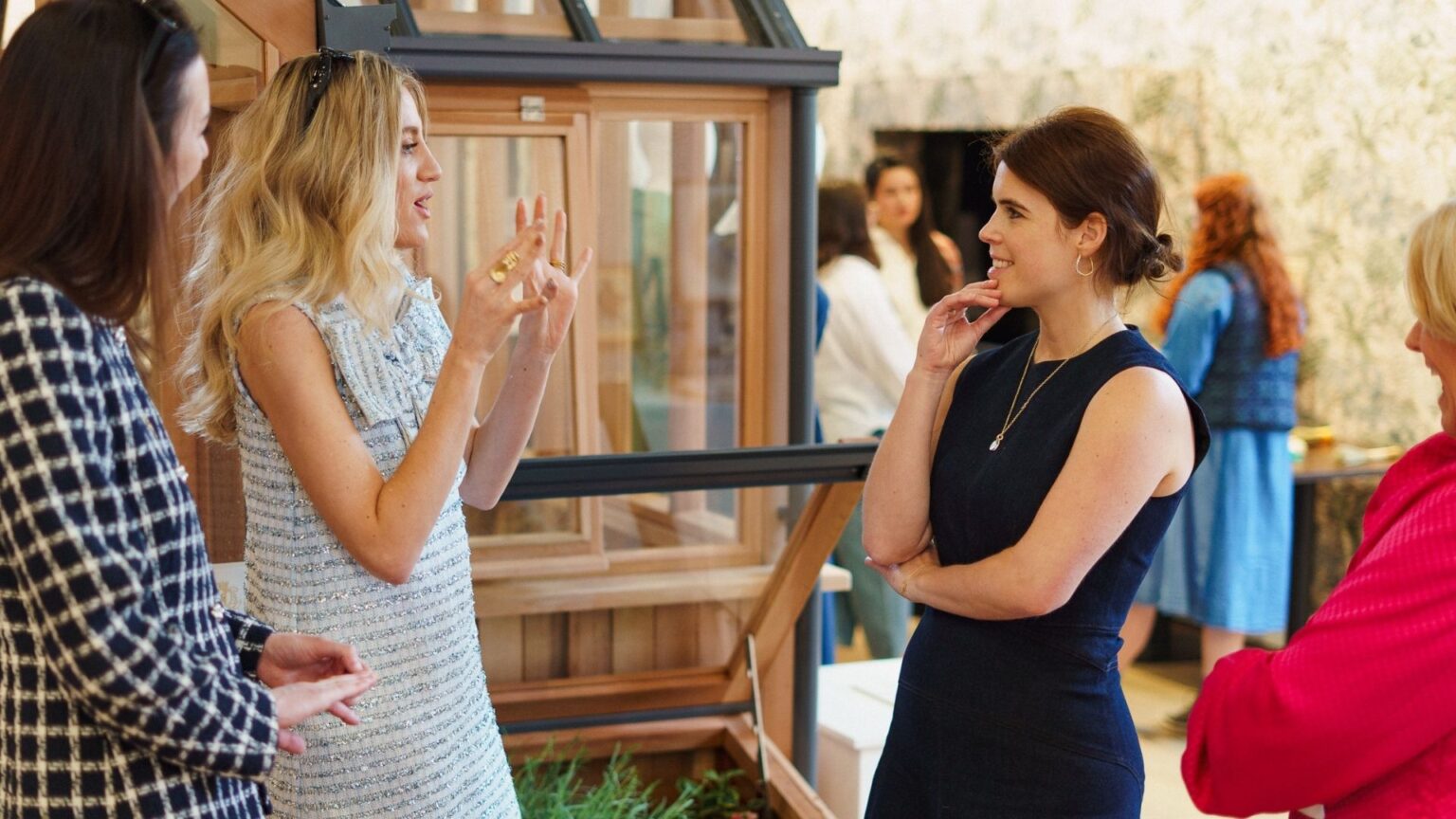 Princess Eugenie wearing a navy dress pictured with The King's Foundation 35 under 35 group