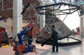 Installation of glass panels for the Apollo-Soyuz Test Project command module's new display case at the California Science Center.