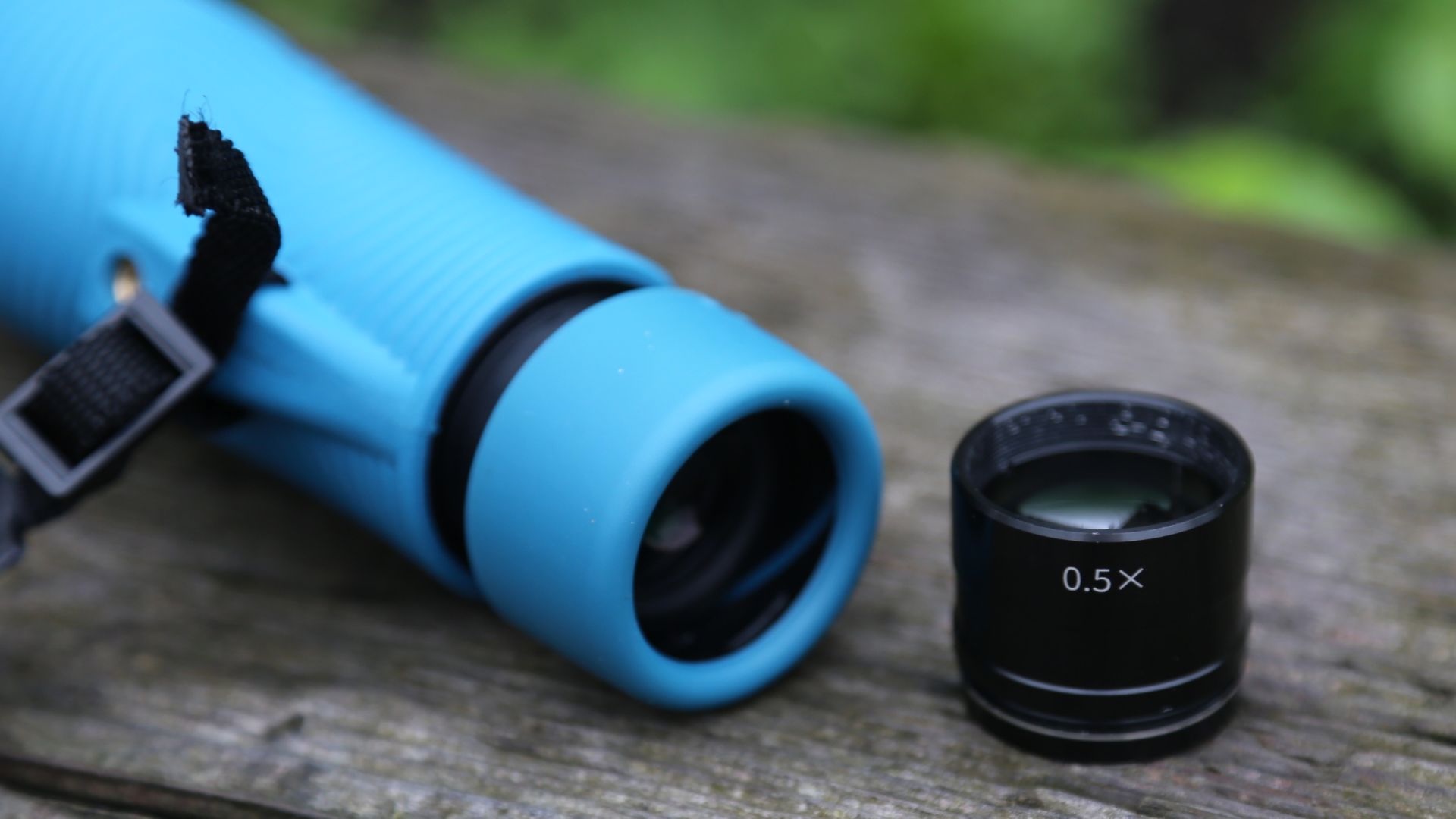 A monocular laying next to a telescope eyepiece.