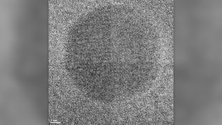 High-resolution TEM image showing tiny inclusion of cubic zirconia inside newly formed zircon. The crystal lattices of two minerals are visible, looking like a fabric texture.
