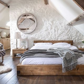 loft conversion bedroom with wooden bed and rough textured walls