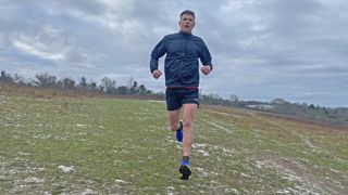 Trail runner wearing Inov8 TrailTalon all-terrain running shoes on a frosty winter run in the hills