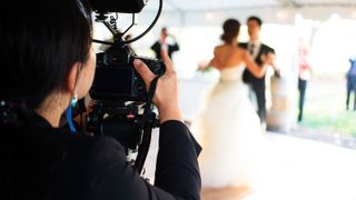 A wedding photographer captures the couple's first dance.