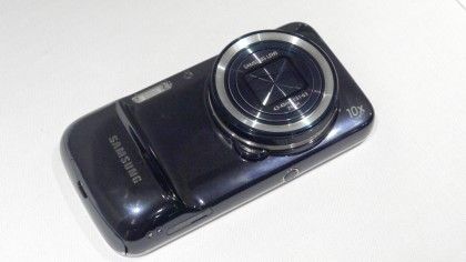 Samsung Galaxy S4 Zoom camera phone on a white table with camera side facing up