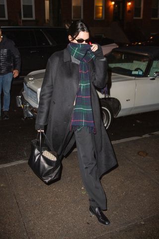 Kendall Jenner in New York City wearing a gray coat and a plaid scarf