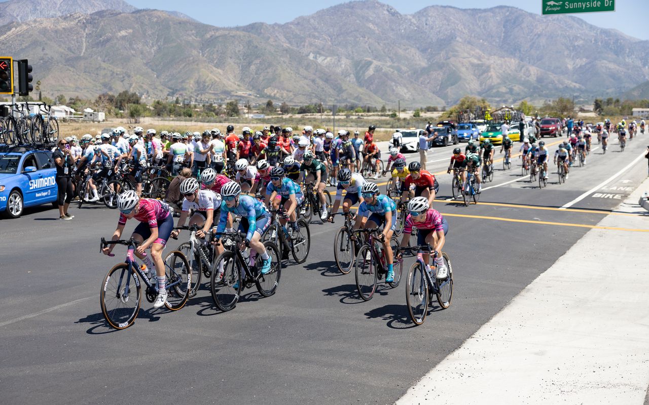 The men's race was neutralized with 2 laps to go because of traffic control issues. The women's peloton passes the stopped men field as they begin their 3rd (of 4) lap.