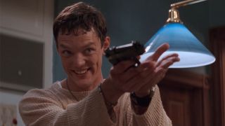 Stu holding a gun and smiling in Scream.