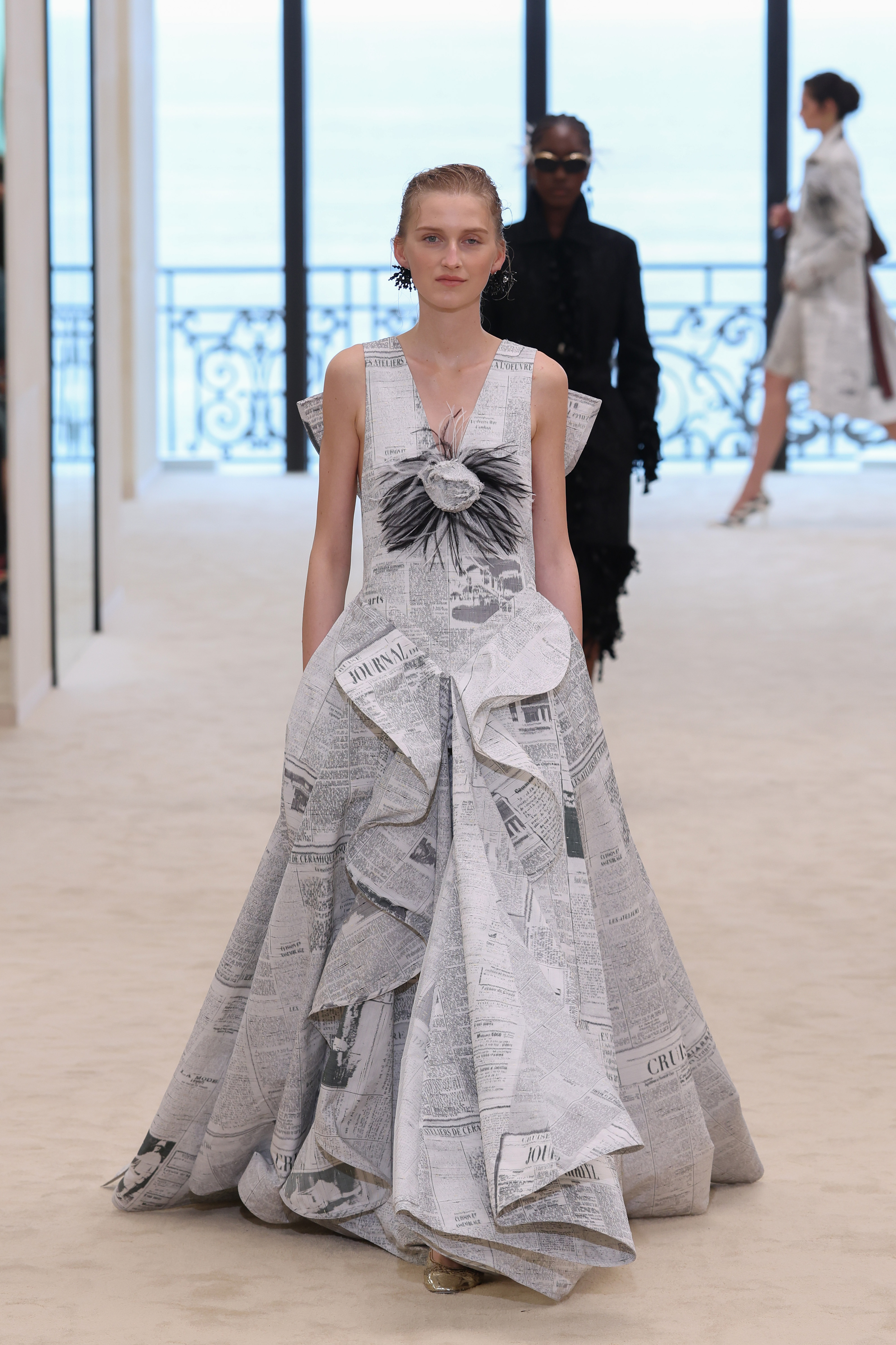 A model wore Chanel's newspaper-print dress on the Cruise 2027 runway