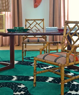 Wooden chair with colorful seat cushion with embroidery, blue patterned rug, wooden dining table