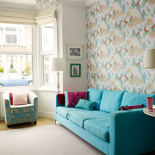 living room with wallpaper and blue sofa