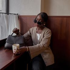 aida badji wearing cardigan and oversized sunglasses