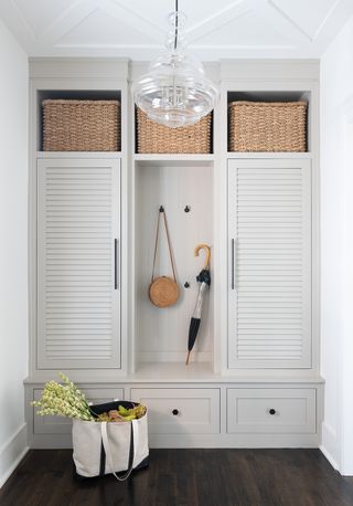 mudroom ideas with white cupboards and wicker baskets