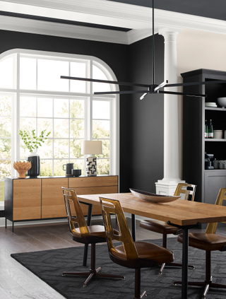 A black and white kitchen with a wooden dining table