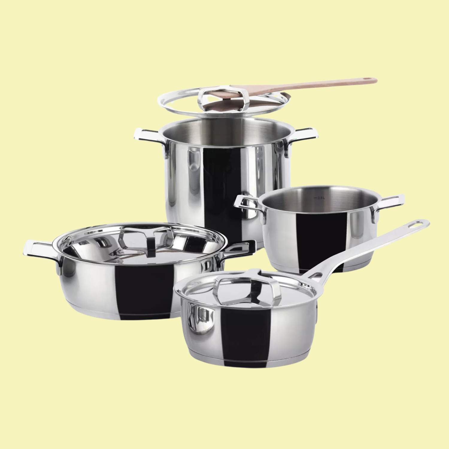 A seven-piece stainless steel kitchen set of pots and pans from Alessi, against a soft yellow background