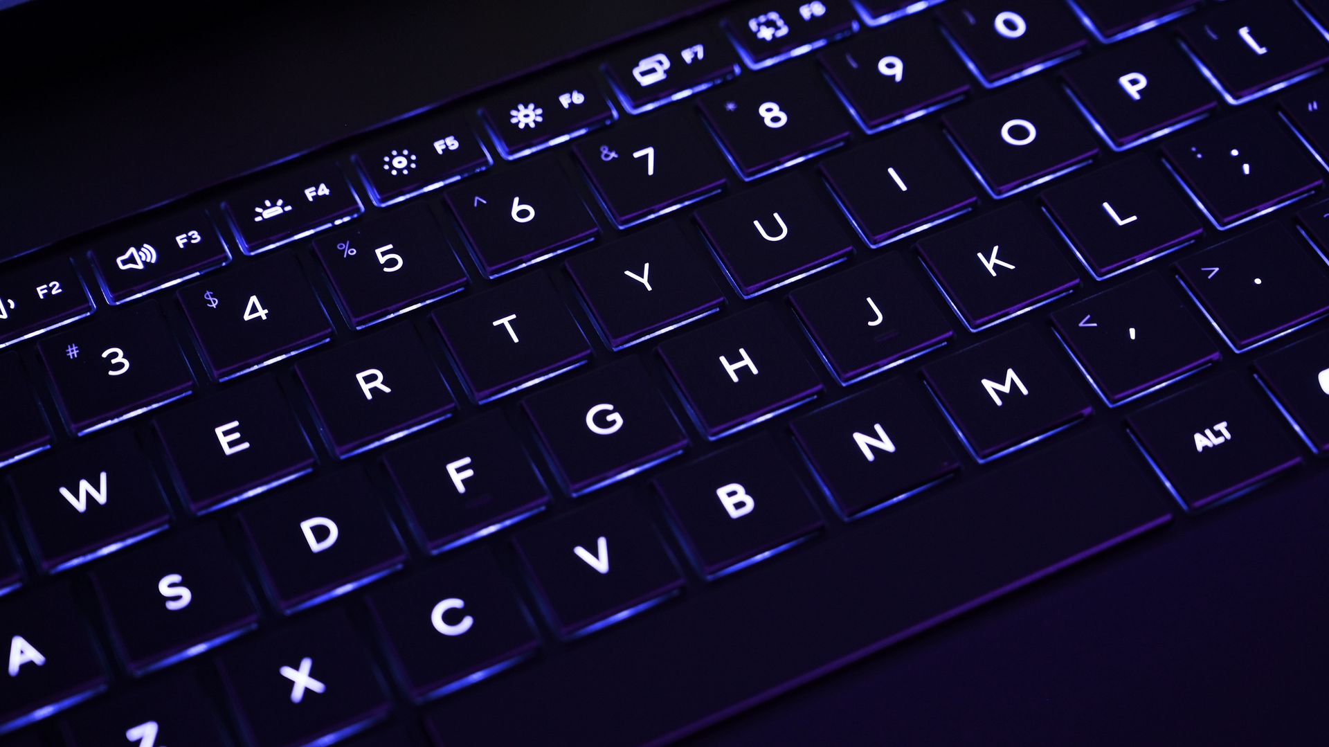Close-up of the ASUS ProArt P16 backlit keyboard illuminated with cool white-blue backlighting under dark ambient lighting.