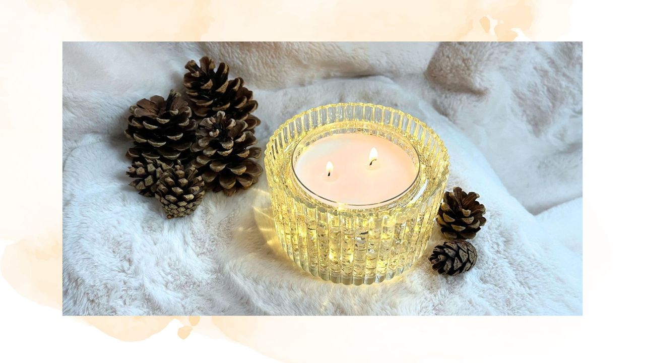 picture of light up candle surrounded by pinecones