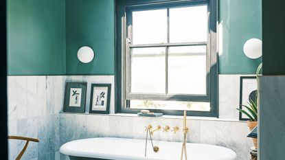 blue bathroom with large window and bath
