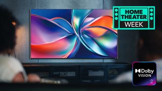 The Dolby Vision 2 logo, with a TV showing a colorful image, watched by a woman