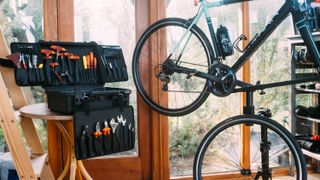 A bike sits in a workstand beside a well-stocked toolbox