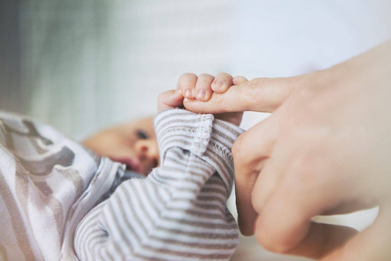 Baby holding mother&#039;s hand