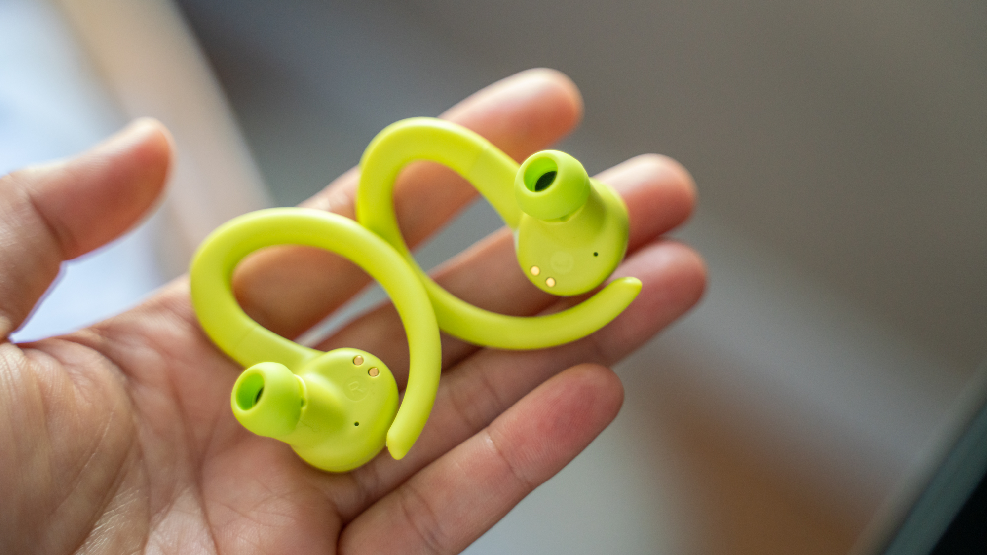 Jlab Go Air Sport in yellow in the reviewer's hand