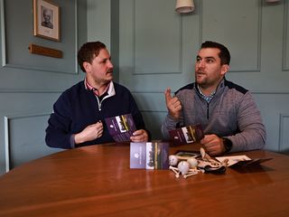 Two golfers filling in their scorecards after their round of golf