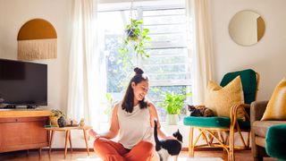 Woman sitting on mat with cat