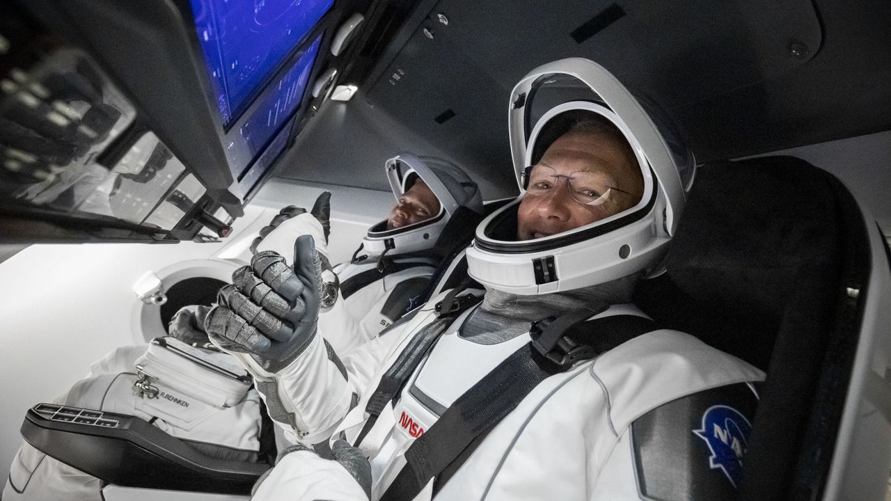 NASA astronauts Doug Hurley (foreground) and Bob Behnken give a thumbs up from inside the Crew Dragon capsule ahead of the Demo-2 launch on May 30, 2020.