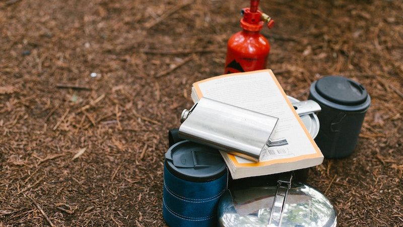 flask with outdoor gear on ground