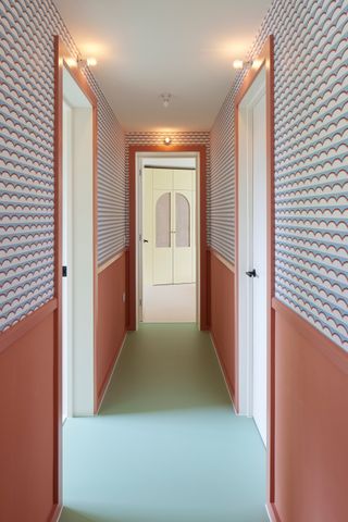 a hallway with bold color and wallpaper