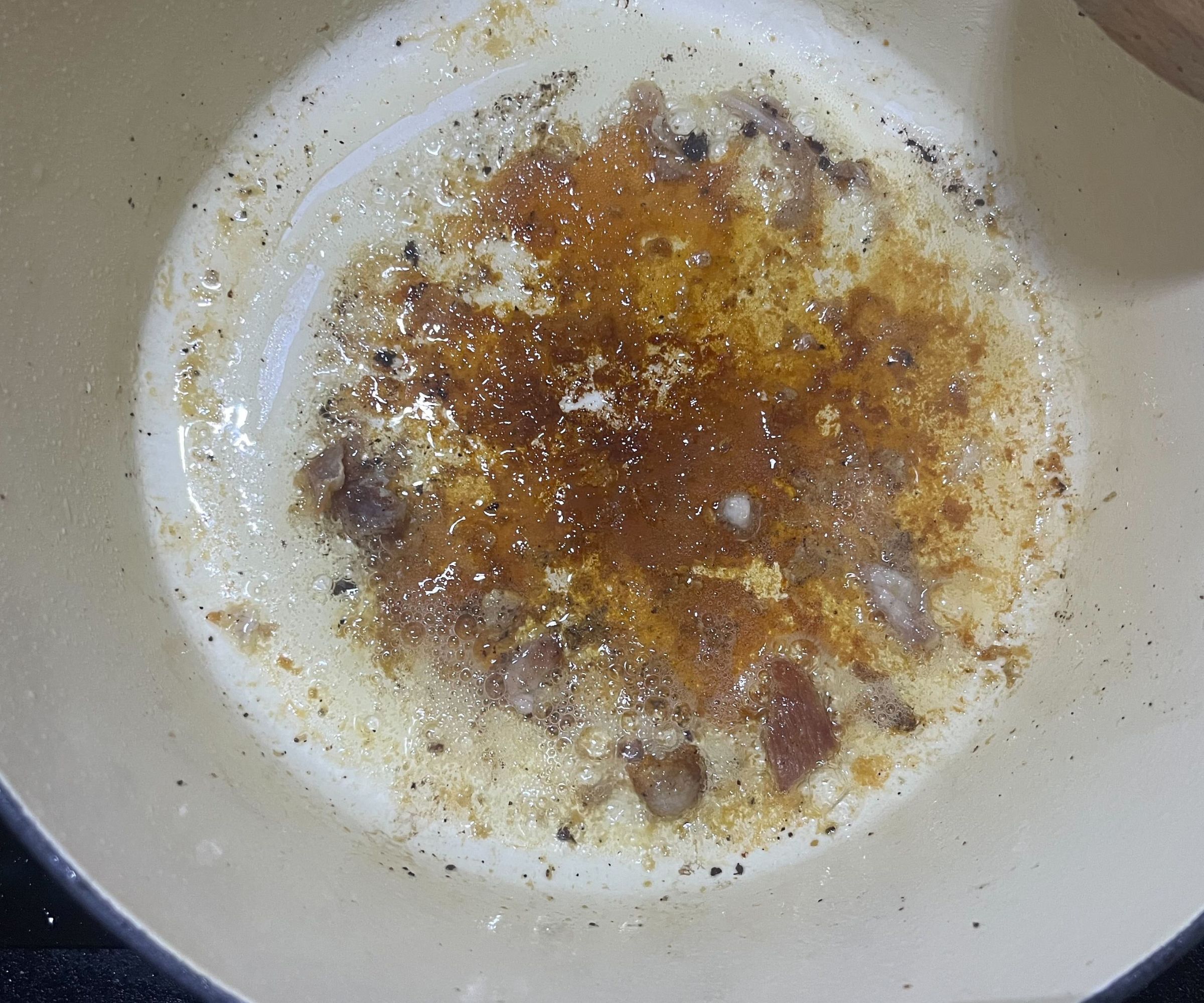 The base of a white Dutch oven with a golden fond