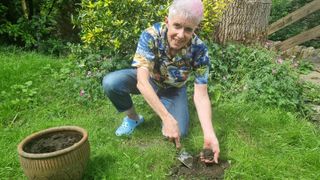 Woman using a small trowel to capture the soil created by mole hills on a lawn and moving it to a pot