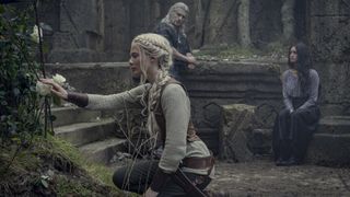 Ciri kniet neben einer Rose, während Geralt und Yennefer in The Witcher Staffel 3 zuschauen