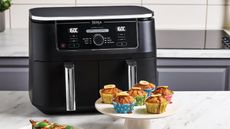 The Ninja Foodi Max Dual Drawer Air Fryer on the counter with a batch of muffins in front of it to show how we test air fryers